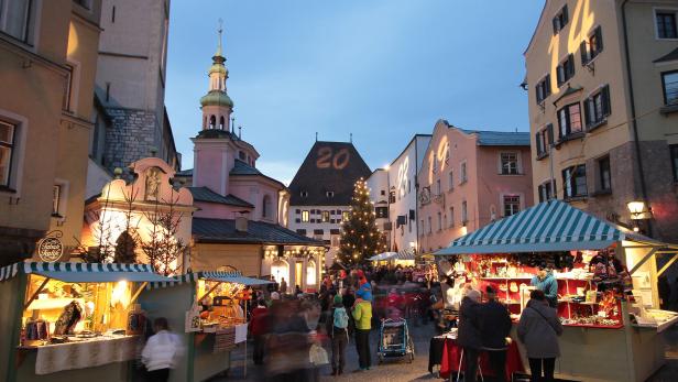 Der Adventmarkt in Hall in Tirol mit geschmücktem Weihnachtsbaum und beleuchteten Buden.