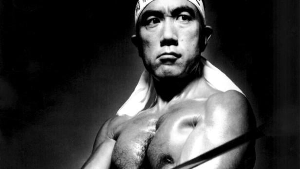 Yukio Mishima  in der Rolle eines idealisierten japanischen Kriegers, der das Stirnband eines Kamikaze trägt und ein Schwert schwingt