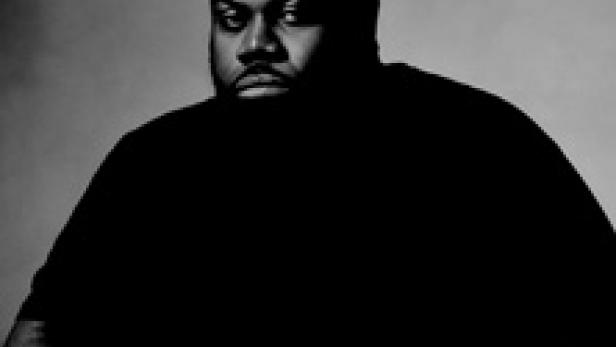 Ein Porträt des Rappers Big Narstie vor einem neutralen Hintergrund.