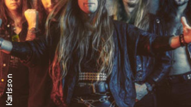 Eine Heavy-Metal-Band posiert in Lederkleidung für ein Gruppenfoto.