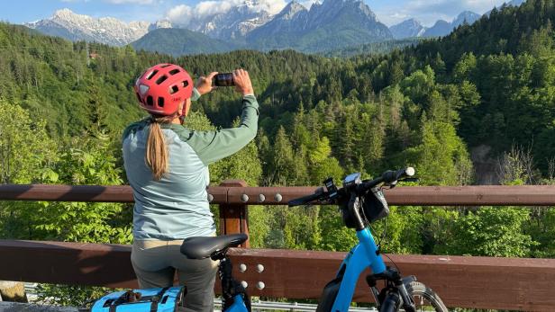 Frau mit Fahrrad fotografiert Berge