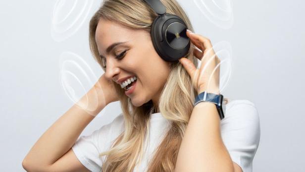 Eine Frau hat Kopfhörer auf und genießt es Musik zu hören.