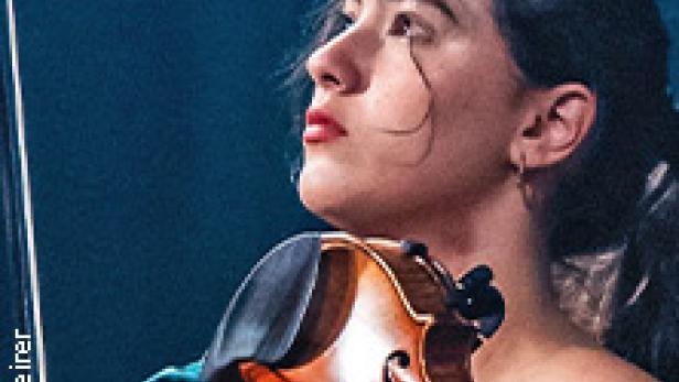 Eine junge Frau spielt Violine, den Kopf leicht zur Seite geneigt.