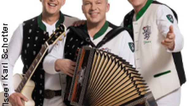 Die Edlseer posieren mit Gitarre und Akkordeon vor einem weißen Hintergrund.