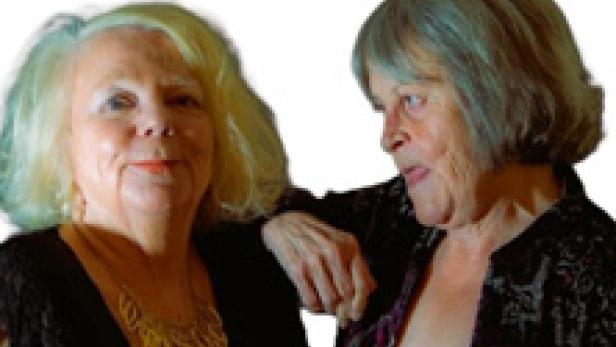 Zwei ältere Frauen stehen nebeneinander und lächeln.