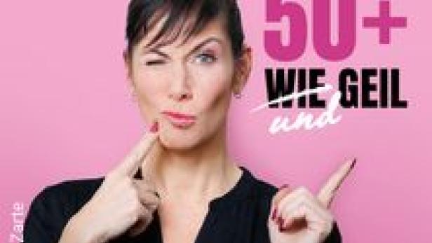 Adriana Zartl posiert vor einem pinkfarbenen Hintergrund mit dem Schriftzug „50+ WIE GEIL und“.