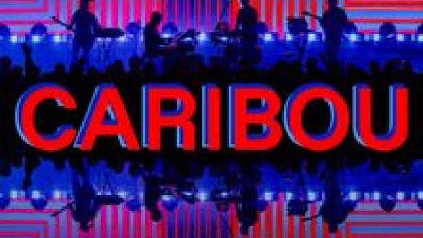 Die Band Caribou spielt vor einem blauen und roten Hintergrund.