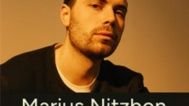 Ein Porträt des Musikers Marius Nitzbon vor einem beigen Hintergrund.