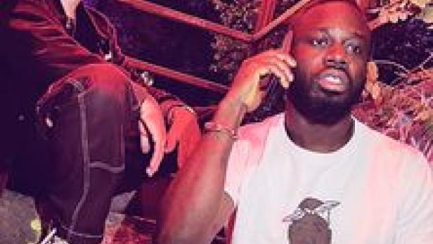 Zwei Männer posieren für ein Foto; einer telefoniert.