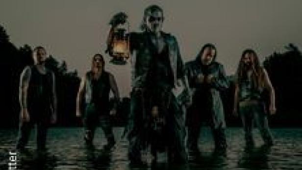 Eine Band steht im Wasser, der Sänger hält eine Laterne in der Hand.