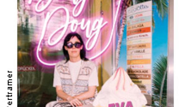 Eva Karl Faltermeier posiert vor einem überdimensionalen Eis und einem Leuchtschild mit der Aufschrift „Ding Dong“.