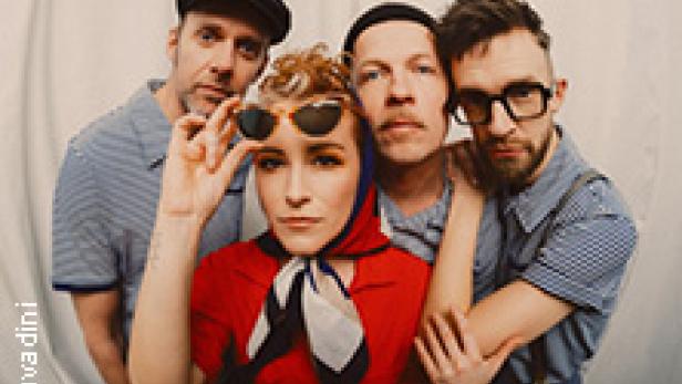 Die Band Querbeat posiert vor einem weißen Hintergrund.