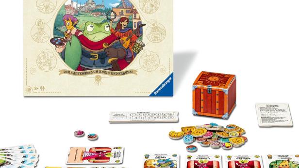 Spielschachtel von „Die glorreichen Gilden von Buttonville“ von Ravensburger mit Spielmaterial wie Karten, Chips und einer kleinen Schatztruhe auf einem Tisch.