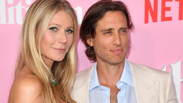 Gwyneth Paltrow und Brad Falchuk vor pinkem Hintergrund.