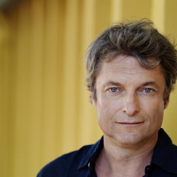 Porträt des österreichischen Schauspielers Alfred Dorfer vor einem gelben Hintergrund.
