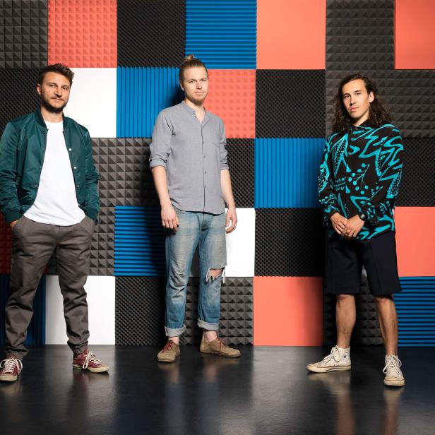 Die Band Folkshilfe posiert vor einer Wand mit Akustikelementen.