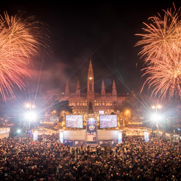 Feuerwerk über dem Wiener Rathaus beim Silvesterpfad mit vielen Menschen.