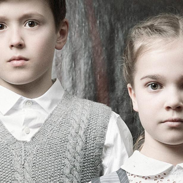 Ein Junge und ein Mädchen stehen vor einem gerahmten Gemälde, ähnlich dem Film „Fanny und Alexander“.