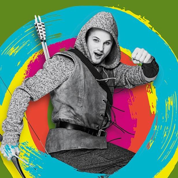 Ein Mann in Robin-Hood-Kostüm posiert mit Pfeil und Bogen vor farbigem Hintergrund.