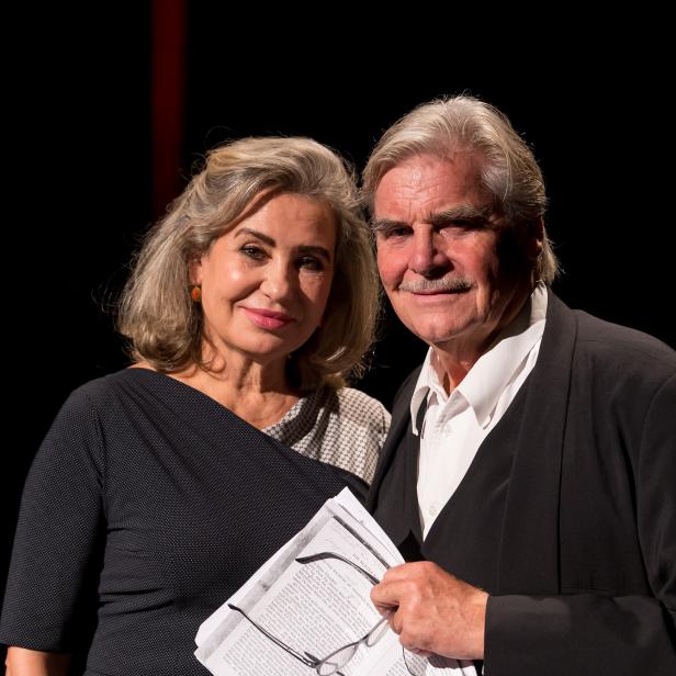 Eine Frau und ein Mann, möglicherweise bei einer Preisverleihung, mit einem Buch in der Hand.