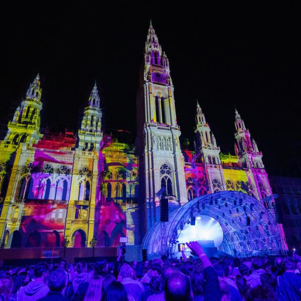 Das Wiener Rathaus ist während einer Veranstaltung mit bunten Lichtern beleuchtet.