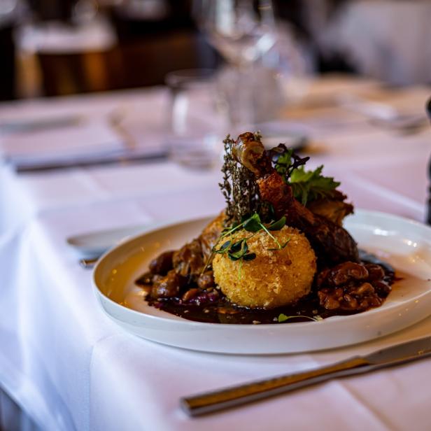 Eine vegane Gans mit Knödel und Beilagen, serviert in einem Restaurant.