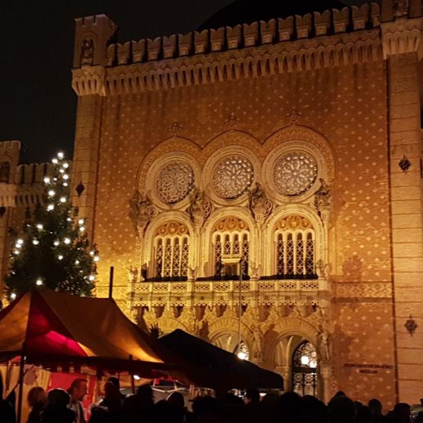 Ein Weihnachtsmarkt vor dem Heeresgeschichtlichen Museum in Wien bei Nacht.