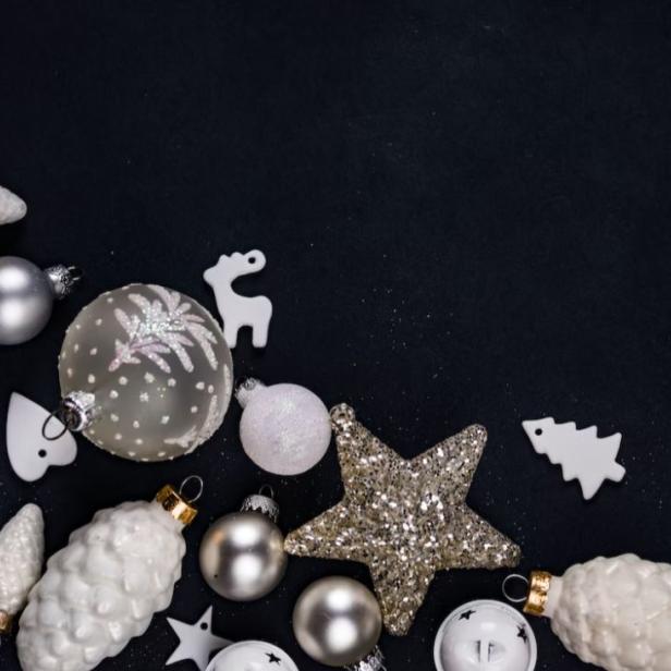 Weihnachtsschmuck in Silber und Weiß auf dunklem Hintergrund.