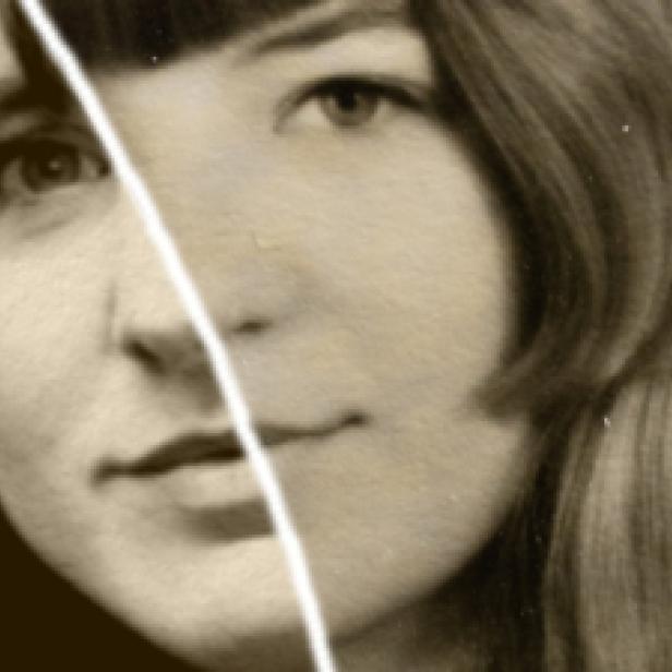 Ein Porträt einer jungen Frau mit Pony und langen Haaren in Sepia-Farben.