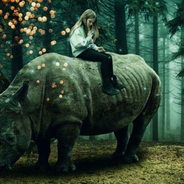 Ein Mädchen sitzt auf dem Rücken eines Nashorns in einem Wald mit Lichtern.