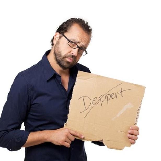 Ein Mann hält ein Pappschild mit der Aufschrift „Deppert“.