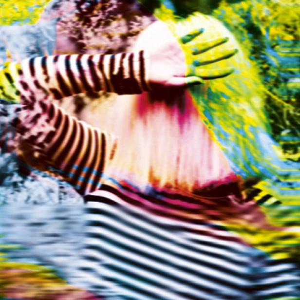 Eine Person in einem gestreiften Oberteil hält die Hand vor das Gesicht.