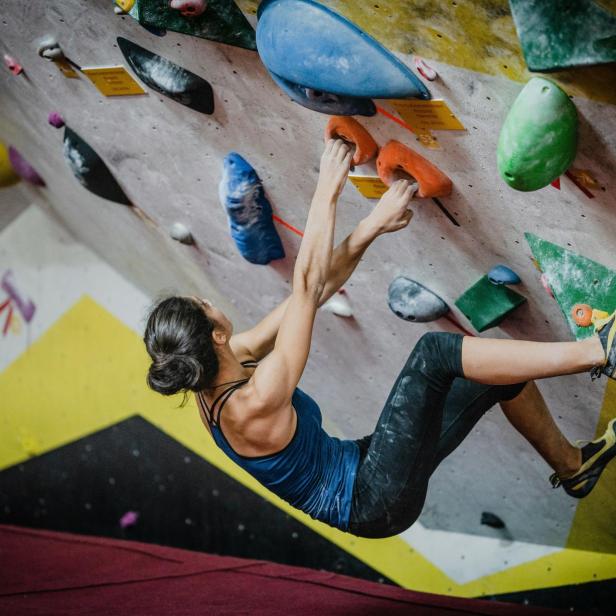 Eine Frau klettert auf einer Kletterwand.