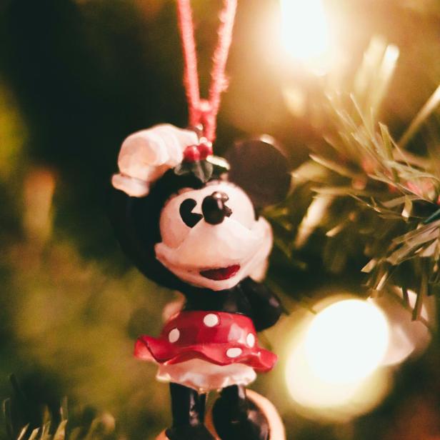 Eine Minnie Maus-Weihnachtsbaumkugel hängt an einem Weihnachtsbaum.