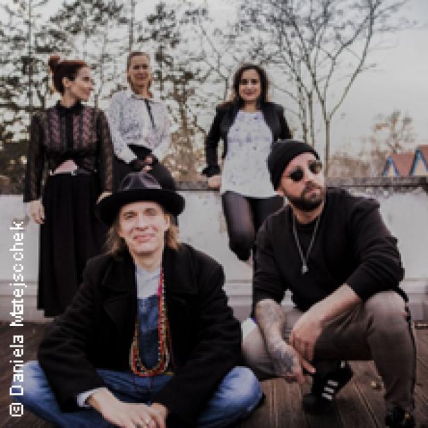 Eine Musikgruppe posiert für ein Gruppenfoto im Freien.