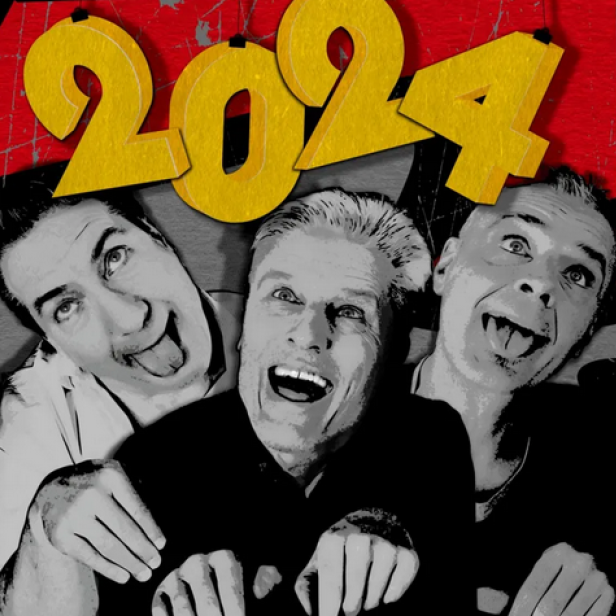 Drei Männer umarmen sich lachend unter der gelben Zahl „2024“.