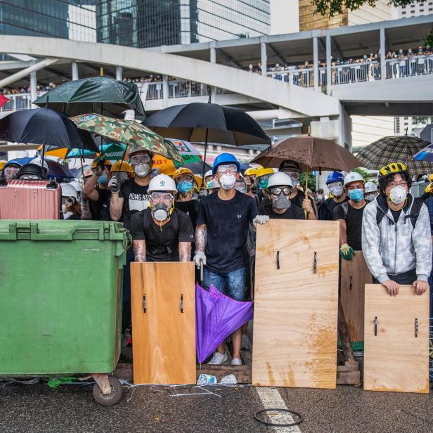 Menschen mit Masken protestieren.