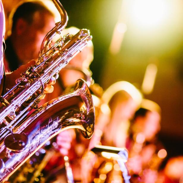 Ein Saxophonist spielt in einer Jazzband auf der Bühne.