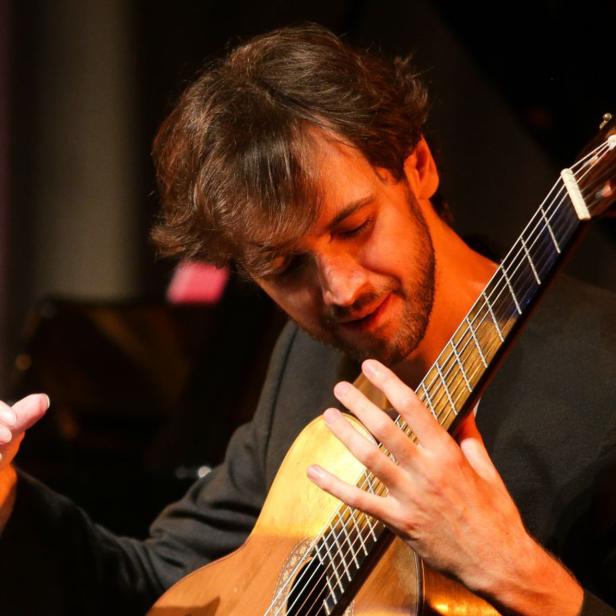 Petrit Çeku spielt auf einer klassischen Gitarre.