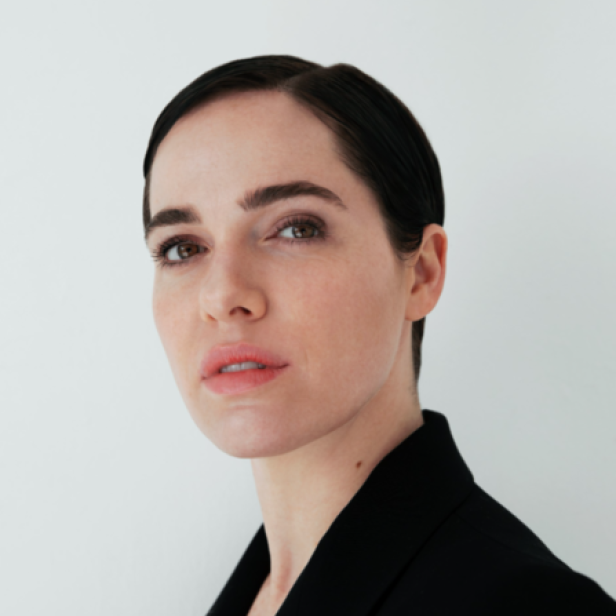 Eine Frau mit dunklen, kurz geschnittenen Haaren und einem schwarzen Blazer.
