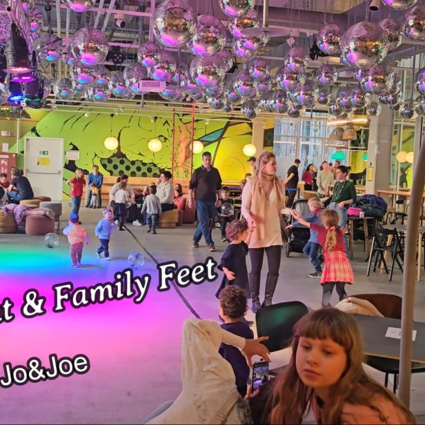 In einem Raum voller Discokugeln tanzen Kinder und Erwachsene.