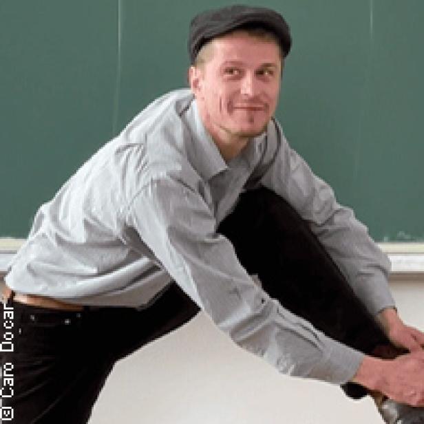 Ein Mann mit Schirmmütze sitzt auf einem Tisch und bindet seine Schuhe.