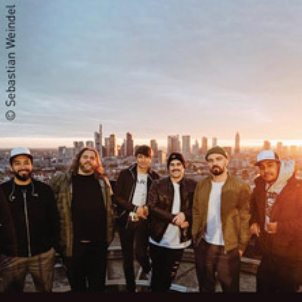 Die Hip-Hop-Band Genetikk posiert vor der Skyline von Frankfurt am Main.