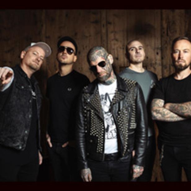 Die Band The Rumjacks posiert vor einer Holzwand.