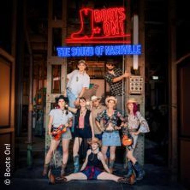 Eine Gruppe von Personen posiert vor einem Neonreklameschild mit der Aufschrift „Boots On! The Sound of Nashville“.