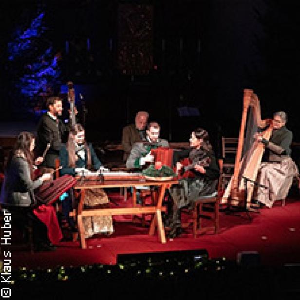 Eine Gruppe von Musikern spielt traditionelle Instrumente auf einer Bühne.