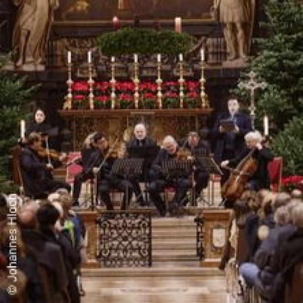 Ein Orchester spielt in einer Kirche vor einem Publikum.