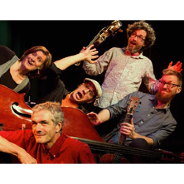 Fünf Musiker posieren mit ihren Instrumenten für ein Gruppenfoto.