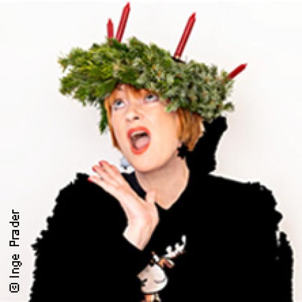 Eine Frau mit einem Adventskranz auf dem Kopf singt.