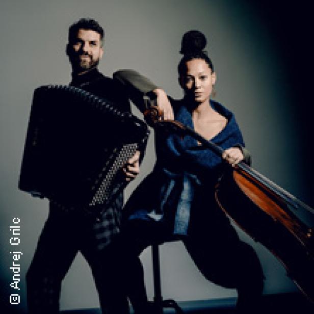 Ein Mann mit Akkordeon und eine Frau mit Cello posieren für ein Foto.